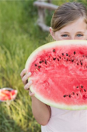 simsearch:6118-07731949,k - A child holding half a fresh water melon. Photographie de stock - Premium Libres de Droits, Code: 6118-07731963