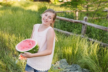 simsearch:6118-07731949,k - A child holding half a fresh water melon. Photographie de stock - Premium Libres de Droits, Code: 6118-07731960