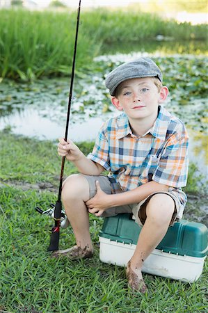 portrait of red-headed 10 year old boy walking with a fishing rod at the  bank of a river Stock Photo - Alamy