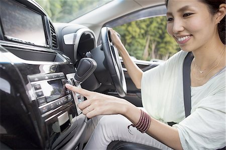 rádio - A young woman sitting in her car. Stock Photo - Premium Royalty-Free, Code: 6118-07808989