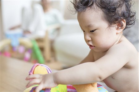 Baby boy playing indoors. Photographie de stock - Premium Libres de Droits, Code: 6118-07808996