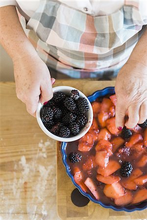 Woman pouring stewed fruit into a pie dish. Fresh blackberries. Stockbilder - Premium RF Lizenzfrei, Bildnummer: 6118-07808931