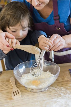 simsearch:6118-08971487,k - A woman and a child cooking at a kitchen table, making fairy cakes. Stockbilder - Premium RF Lizenzfrei, Bildnummer: 6118-07808934