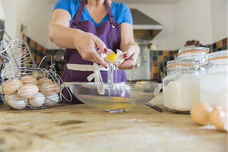 simsearch:6102-08951511,k - A woman at a kitchen table baking fairy cakes. Stock Photo - Premium Royalty-Free, Code: 6118-07808936