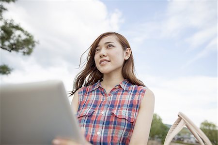 simsearch:6118-07813281,k - Young woman with a digital tablet in the park. Stock Photo - Premium Royalty-Free, Code: 6118-07813264