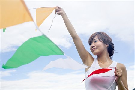 simsearch:6118-07813281,k - A woman in a Kyoto park holding up a colourful row of flags. Stock Photo - Premium Royalty-Free, Code: 6118-07813239