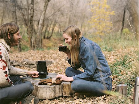 simple whole body - Smiling couple sitting on the ground in a forest, drinking coffee. Stock Photo - Premium Royalty-Free, Code: 6118-07944769