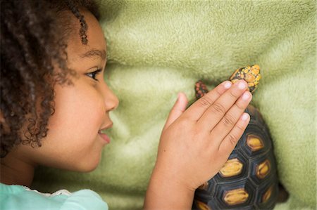 A young girl looking closely at a tortoise. Photographie de stock - Premium Libres de Droits, Code: 6118-08081859