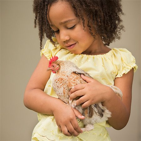 simsearch:6118-08081851,k - A young girl holding a chicken in her arms. Foto de stock - Sin royalties Premium, Código: 6118-08081864