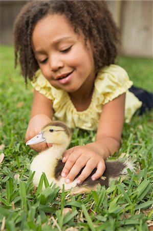 A girl petting a small duckling. Stock Photo - Premium Royalty-Free, Code: 6118-08081871