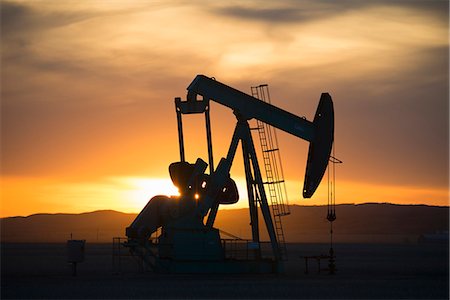 A pumpjack at an oil drilling site at sunset. Foto de stock - Sin royalties Premium, Código: 6118-08088547