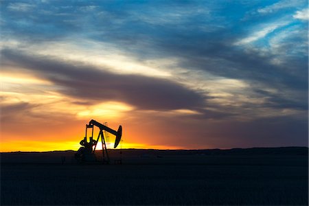 A pumpjack at an oil drilling site at sunset. Foto de stock - Sin royalties Premium, Código: 6118-08088549