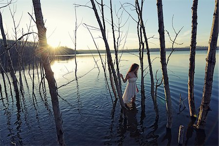 reflection (visual) - A woman in a white dress in shallow water at dusk Stock Photo - Premium Royalty-Free, Code: 6118-08088610