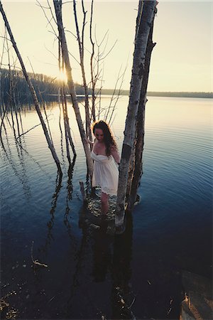 patauger - A woman in a white dress or nightdress in shallow water at dusk Photographie de stock - Premium Libres de Droits, Code: 6118-08088611