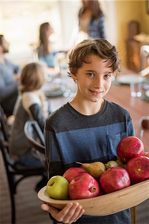 A boy carring a wooden tray of apples. Photographie de stock - Premium Libres de Droits, Code: 6118-08001562