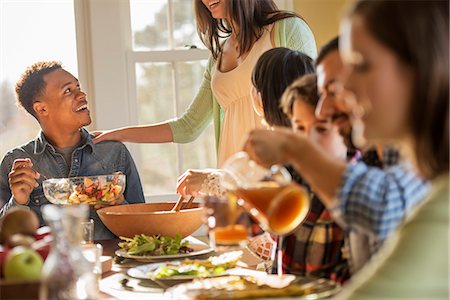 simsearch:6118-07769547,k - A group of people, adults and children, seated around a table for a meal. Stock Photo - Premium Royalty-Free, Code: 6118-08001576