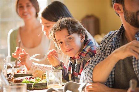 simsearch:6118-07781807,k - A group of people, adults and children, seated around a table for a meal. Stock Photo - Premium Royalty-Free, Code: 6118-08001578