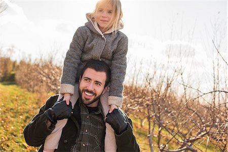 A man giving a child a ride on his shoulders. Photographie de stock - Premium Libres de Droits, Code: 6118-08001587