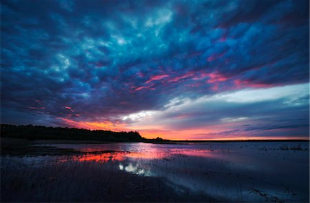 Sunset light on the calm waters of a lake. Photographie de stock - Premium Libres de Droits, Code: 6118-08001502