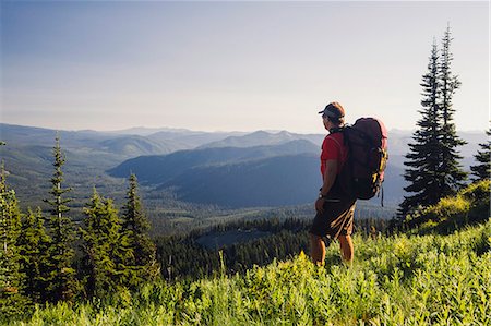 simsearch:6118-07202956,k - Man backpacking in the mountains, walking on a ridge overlooking a valley. Foto de stock - Sin royalties Premium, Código: 6118-08001525