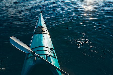 simsearch:6118-07351322,k - An empty sea kayak on calm waters at dusk, with a paddle resting across the seat. Foto de stock - Sin royalties Premium, Código: 6118-08001533