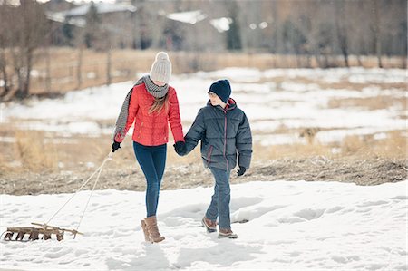 simsearch:6118-08023790,k - A brother and sister in the snow, one pulling a sledge. Stock Photo - Premium Royalty-Free, Code: 6118-08023783