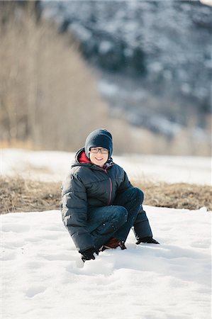 simsearch:6118-08488428,k - A boy in a blue coat and woolly hat in the snow. Stock Photo - Premium Royalty-Free, Code: 6118-08023784