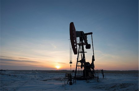 pumpjack - An oil drilling rig and pumpjack on a flat plain in the Canadian oil fields at sunset. Stock Photo - Premium Royalty-Free, Code: 6118-08023711