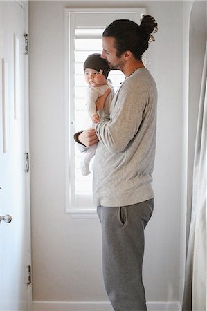 pony tail - A father holding a young baby. Photographie de stock - Premium Libres de Droits, Code: 6118-08023723