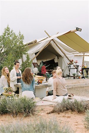 drinking in mountain - Group of women friends sitting on the ground round a table, a tent in the background. Stock Photo - Premium Royalty-Free, Code: 6118-08140186