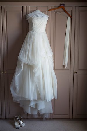 simsearch:6115-07109837,k - Wedding dress hanging on a wardrobe door, wedding shoes on the floor. Stock Photo - Premium Royalty-Free, Code: 6118-08140137