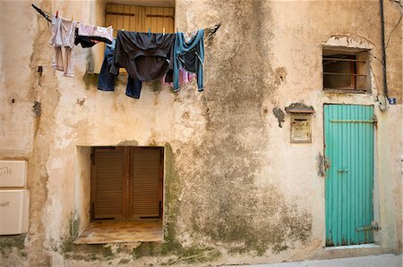 Laundry drying on a washing line outside a house in Bonifacio on Corsica. Fotografie stock - Premium Royalty-Free, Codice: 6118-08140264