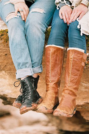 simsearch:6118-08140206,k - Close up of two women wearing leather boots sitting on a rock in a desert. Foto de stock - Royalty Free Premium, Número: 6118-08140222