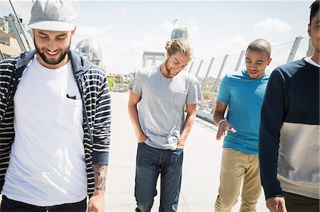 simsearch:6118-08129648,k - Group of young men walking along a bridge. Photographie de stock - Premium Libres de Droits, Code: 6118-08129678