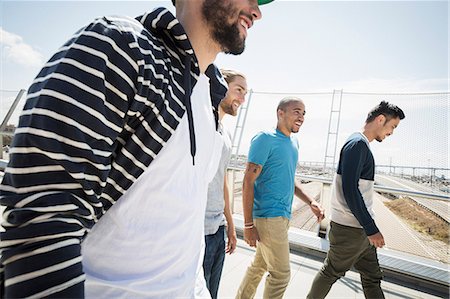 Group of young men walking along a bridge. Photographie de stock - Premium Libres de Droits, Code: 6118-08129679