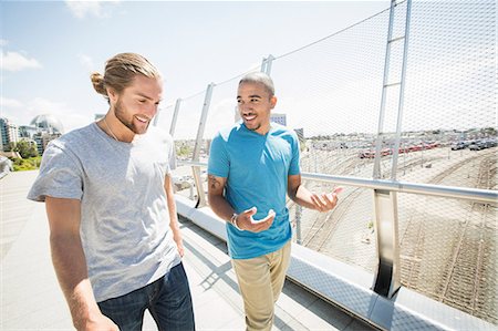 simsearch:6118-08129648,k - Two young men walking along a bridge. Photographie de stock - Premium Libres de Droits, Code: 6118-08129681