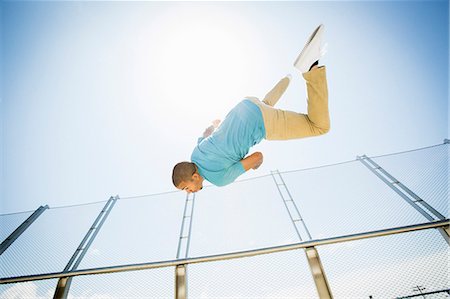 Young man somersaulting on a bridge. Fotografie stock - Premium Royalty-Free, Codice: 6118-08129689