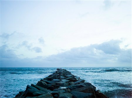 simsearch:6118-08129648,k - View along a groyne built out of rocks onto the ocean. Stock Photo - Premium Royalty-Free, Code: 6118-08129635