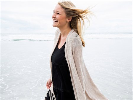 simsearch:6118-08129648,k - Portrait of a smiling young woman on a beach. Photographie de stock - Premium Libres de Droits, Code: 6118-08129700