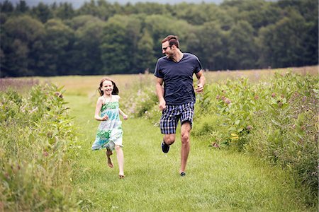 simsearch:6118-09165967,k - A man and a young child running through a wildflower meadow. Foto de stock - Sin royalties Premium, Código: 6118-08243775