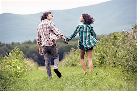 simsearch:6118-08282226,k - A couple, man and woman running through a meadow hand in hand. Photographie de stock - Premium Libres de Droits, Code: 6118-08243793