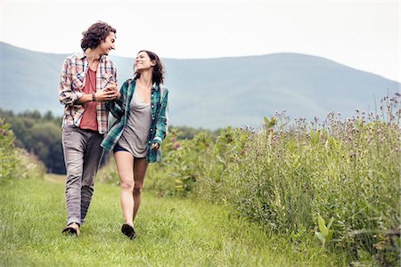 simsearch:6118-08282226,k - A couple, man and woman walking through a meadow in the countryside. Photographie de stock - Premium Libres de Droits, Code: 6118-08243794