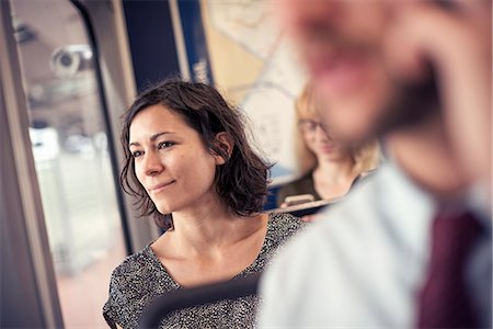 sitting on a bus - A woman on a busy bus looking out of the window Stock Photo - Premium Royalty-Free, Code: 6118-08243850