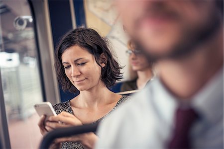 rush hour - A woman on a bus looking down at her cell phone Stock Photo - Premium Royalty-Free, Code: 6118-08243851