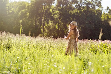 simsearch:6118-07351879,k - A young girl walking in a field in the sunshine Stock Photo - Premium Royalty-Free, Code: 6118-08243905