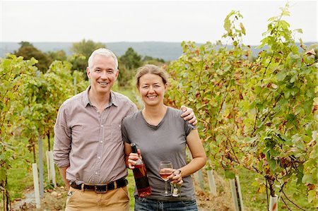 A couple, vineyard founder and her partner standing among the rows of vines. Stock Photo - Premium Royalty-Free, Code: 6118-08282199