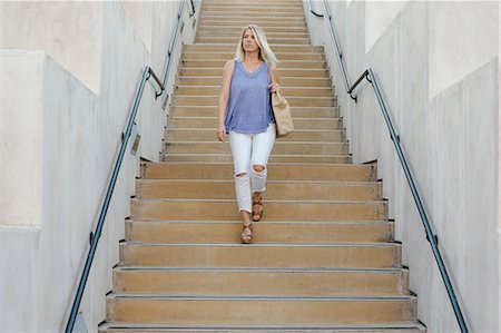 people walking stairs - Blond woman walking down a staircase. Stock Photo - Premium Royalty-Free, Code: 6118-08282266