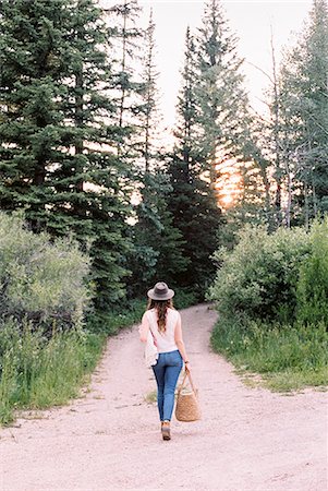 simsearch:6118-08140227,k - Woman walking along a forest path, carrying a bag. Photographie de stock - Premium Libres de Droits, Code: 6118-08282280