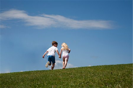 Two children running up a hill Stock Photo - Premium Royalty-Free, Code: 6118-08282218