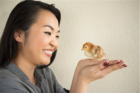 simsearch:6118-09018327,k - Smiling woman holding a tiny chick in her hands. Photographie de stock - Premium Libres de Droits, Code: 6118-08202560